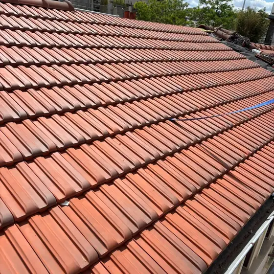 Rénovation de toiture par CN Toiture : tuiles mécaniques neuves posées au cordeau, rives en zinc